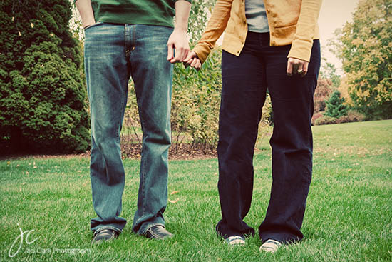 Couple holding hands, walking on a grassy field