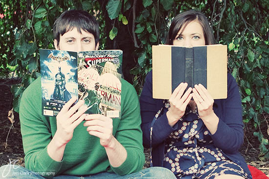 Couple hiding faces with books comic book reading in the park