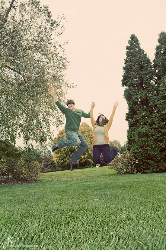 Happy couple jumping in the air in a park, excited and joyful