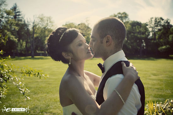 Bride and groom sharing a tender moment outdoors on their wedding day