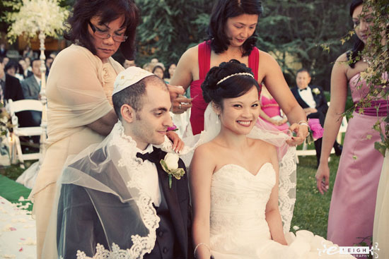 Bride and groom during traditional wedding ceremony with family
