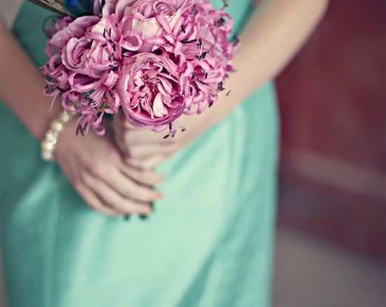 Pink floral bouquet held by woman in mint dress