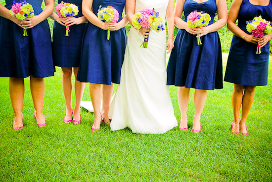 Bridesmaids in navy dresses with pink shoes and colorful bouquets