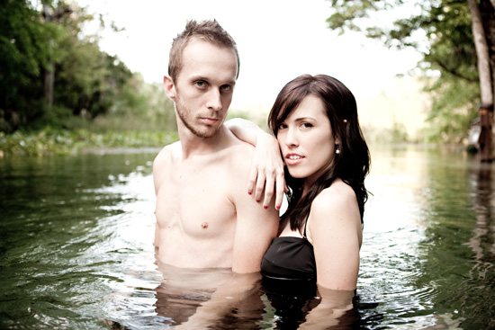 Couple in water posing for a photo in a natural setting