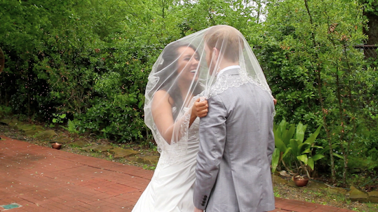 Bride and groom sharing a sweet first look under a veil