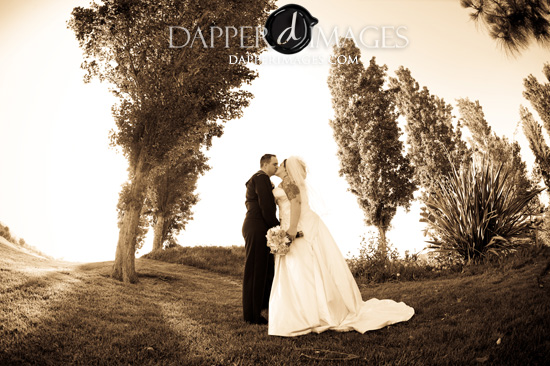 Romantic sepia toned wedding photo of a kissing couple