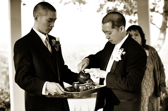 Two groomsmen performing a tea ceremony during a wedding