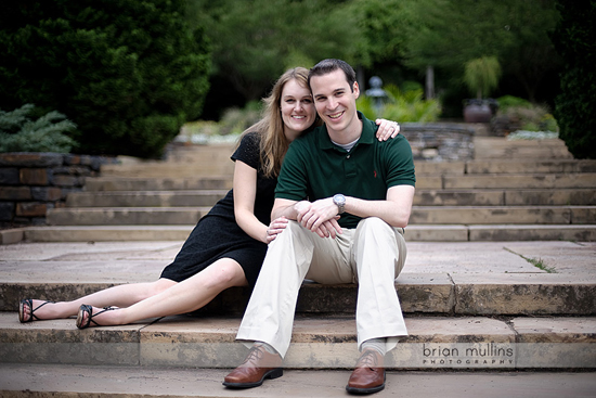 Happy couple sitting on stone steps outdoors smiling