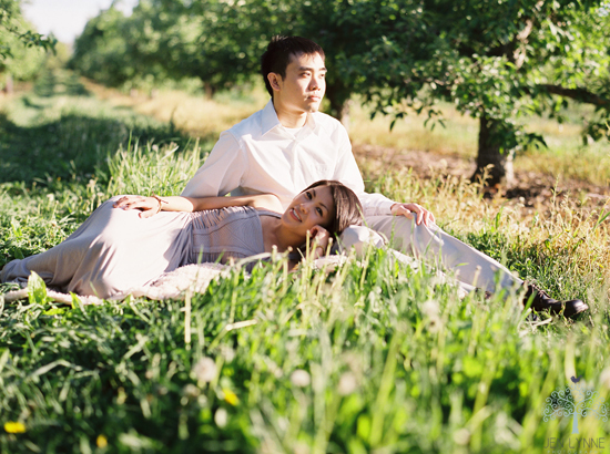 Couple relaxing in sunny orchard grass