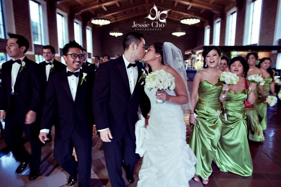 Happy couple kissing at wedding ceremony with bridesmaids