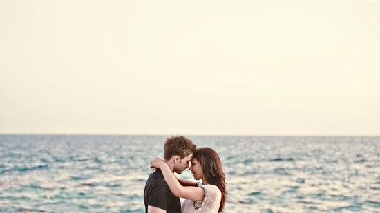 Romantic couple embracing on a beach ocean backdrop