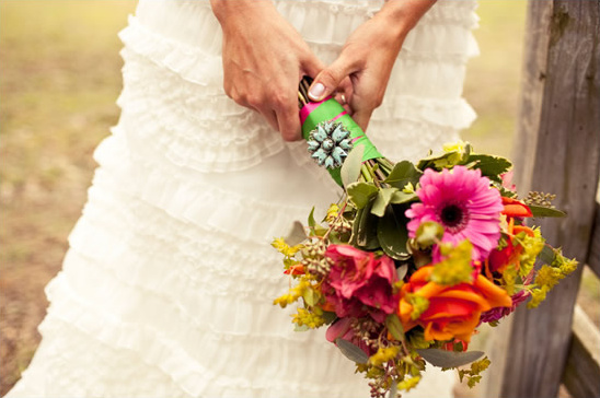 Bride holding vibrant bouquet with colorful flowers
