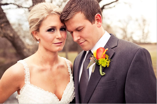 Wedding couple embracing with floral boutonniere and bridal gown