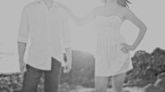 Couple in white standing near the sea