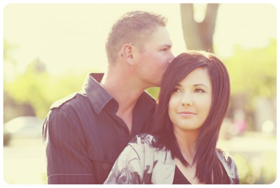 Romantic moment with a man kissing a woman's forehead outdoors