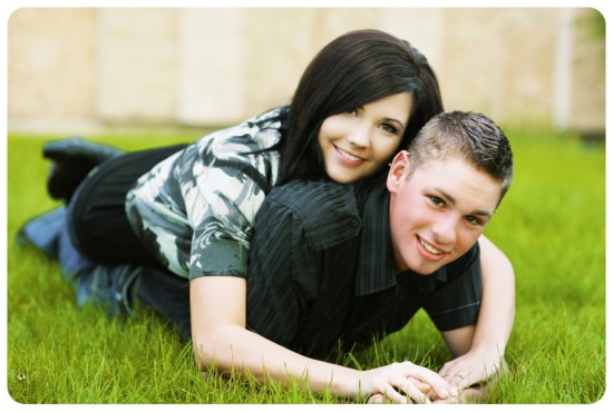 Happy couple smiling while laying on the grass