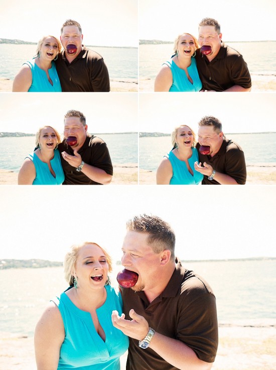 Happy couple sharing an apple by the sea