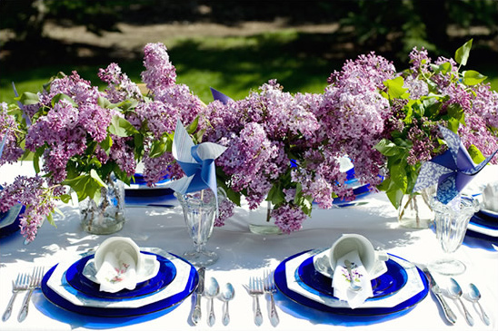 Elegant outdoor dining table with lilac flower bouquets