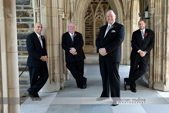 Four groomsmen in suits posing casually for a wedding photo