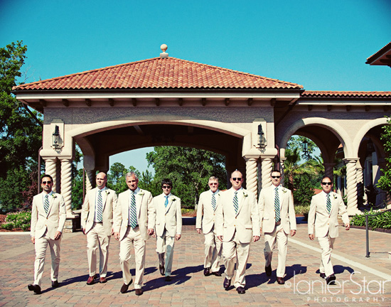groom and groomsmen walking in front of TPC Clubhouse