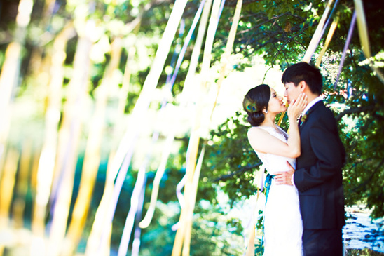 Bride and groom embrace under whimsical ribbons