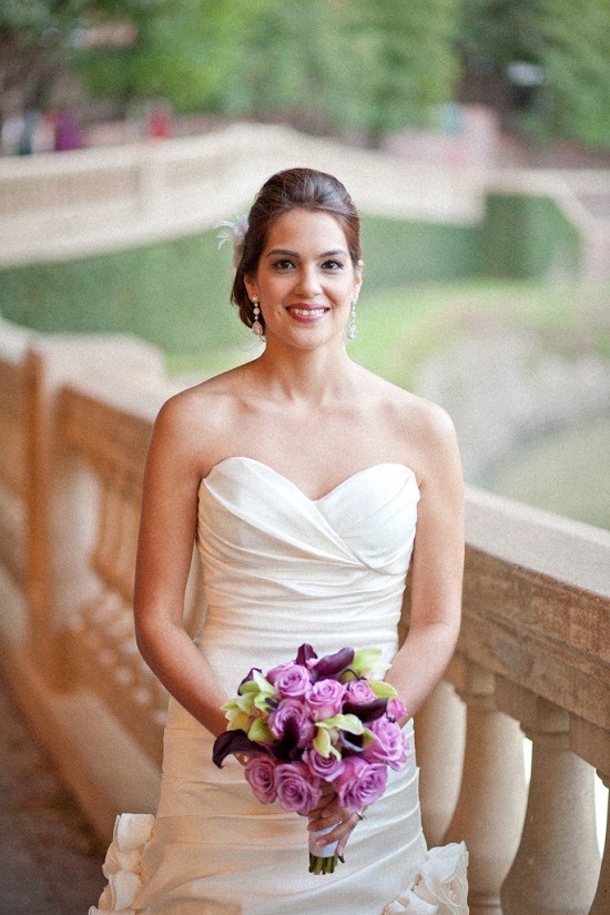Beautiful bride in wedding dress holding purple bouquet