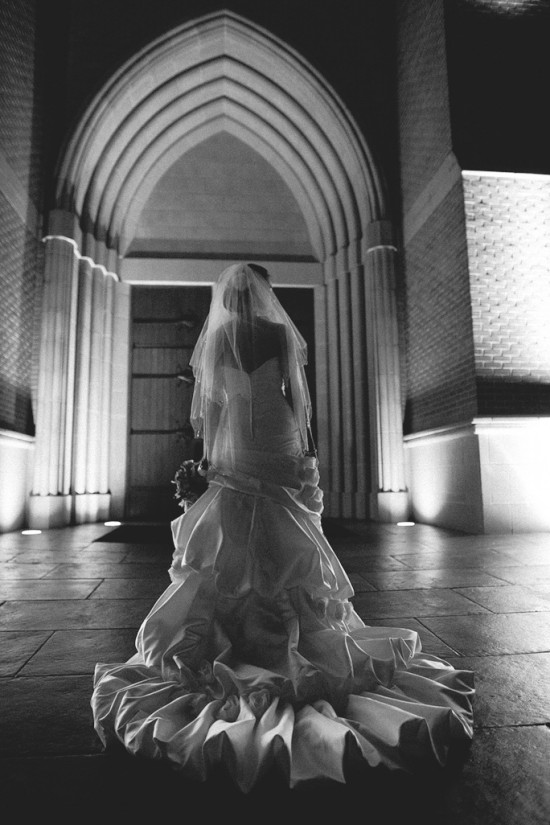 Black and white photo of bride at church entrance