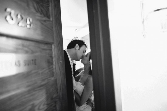Bride and groom sharing a passionate kiss in a hotel room