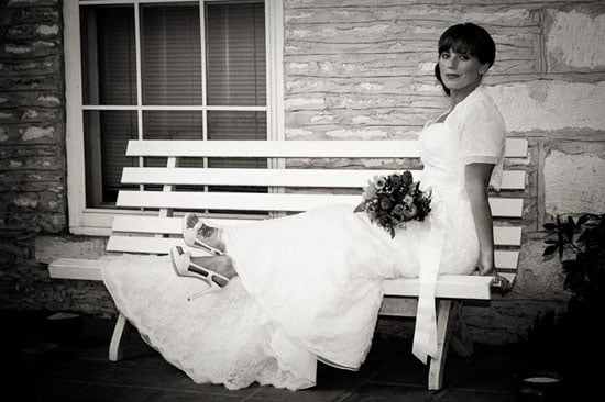 bridal portrait sitting on bench on mansion porch