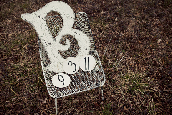 White distressed chair with numbers on a field with grass
