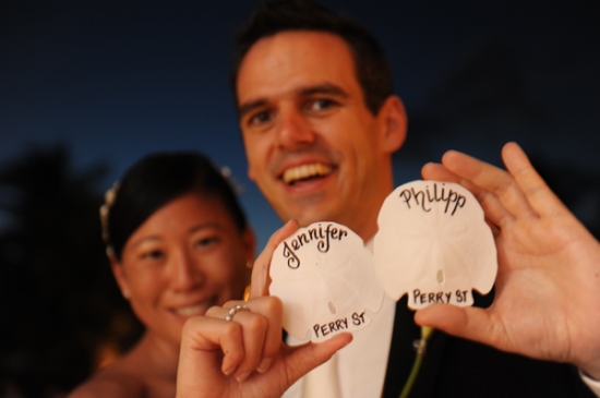 Happy couple holding personalized seashell place cards