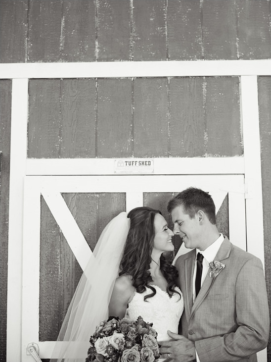 Black and white wedding photo of happy couple at barn