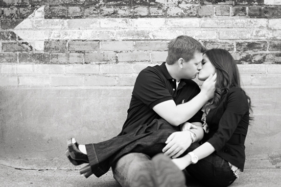 Couple kissing in front of a brick wall, romantic black and white photo
