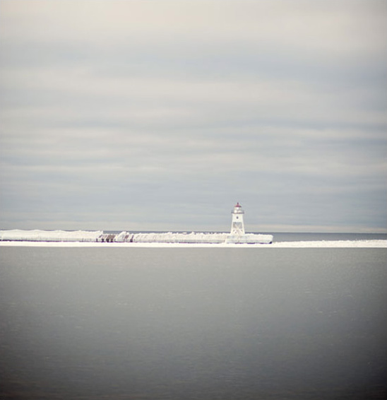 Lighthouse on an icy lake breakwater