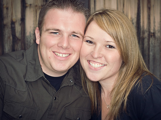 Happy couple portrait in front of rustic wood background