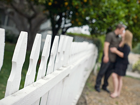 White picket fence with couple in background