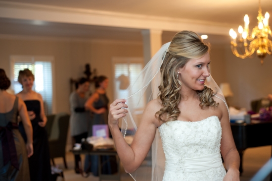 Smiling bride in her wedding dress with her bridesmaids in the background