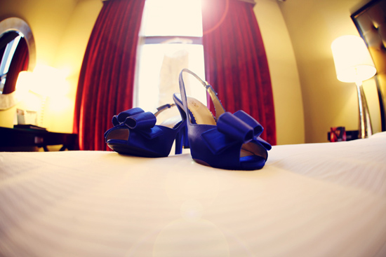Elegant blue wedding shoes on a hotel bed ready for the big day