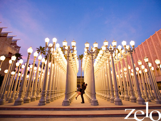 Couple embraces amidst glowing Urban Light sculptures