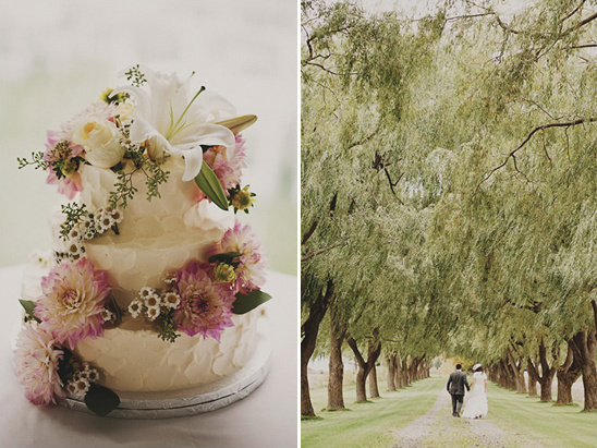 Elegant wedding cake and couple under willow tree arch