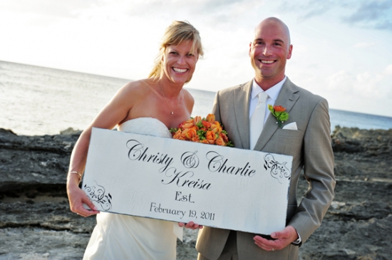 Bride and groom holding wedding sign