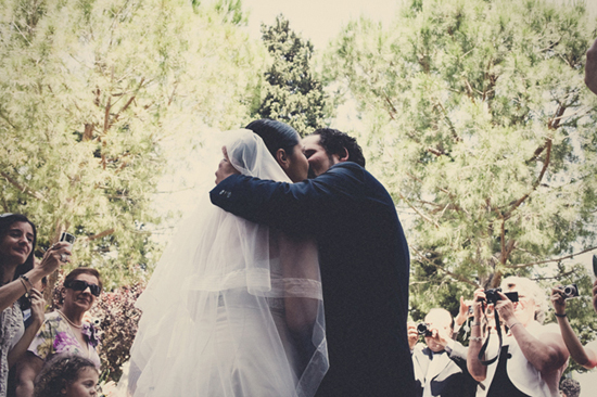 Bride and groom share a tender kiss at their wedding ceremony