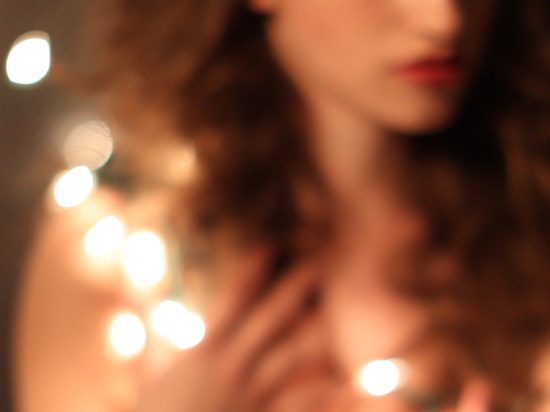 Woman's face with blurred fairy lights around her
