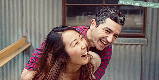 Happy couple laughing outdoors together piggyback ride