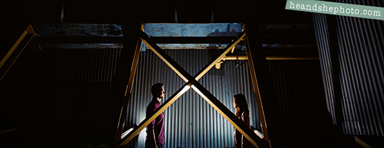Romantic couple silhouetted against industrial backdrop