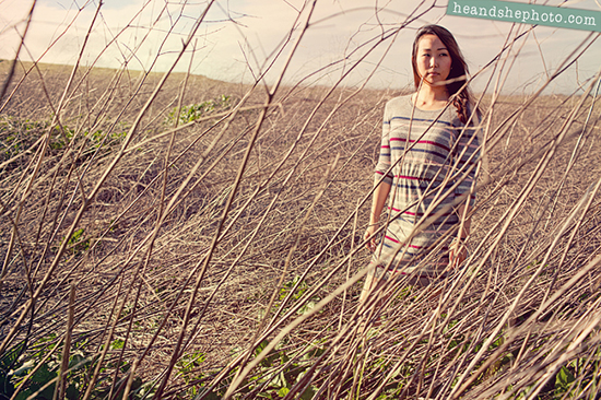 Woman in striped dress walking through tall grass