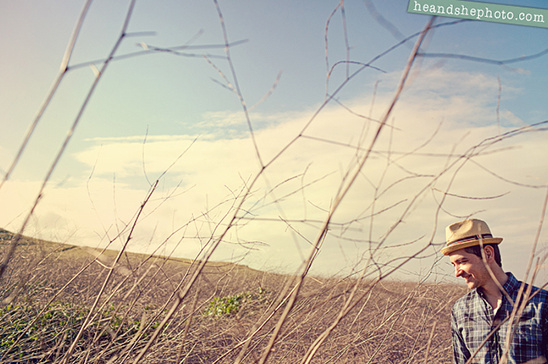 Man in hat standing in dry field under blue sky