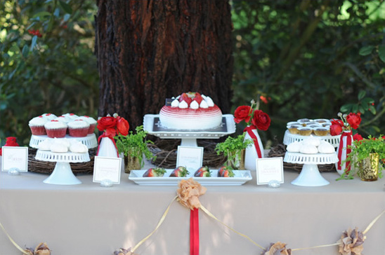 Elegant red and white dessert table with cake and cupcakes