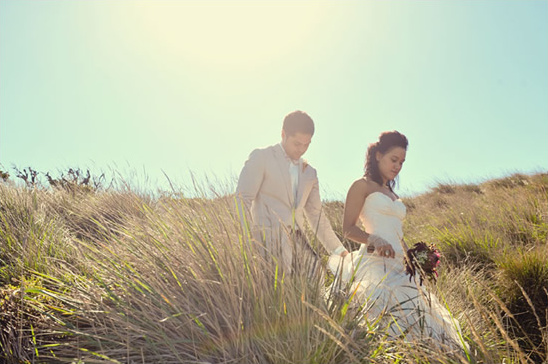 Couple in wedding attire walking field