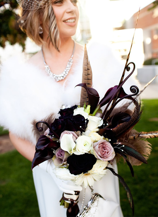 Bride with vintage bouquet of roses and feathers